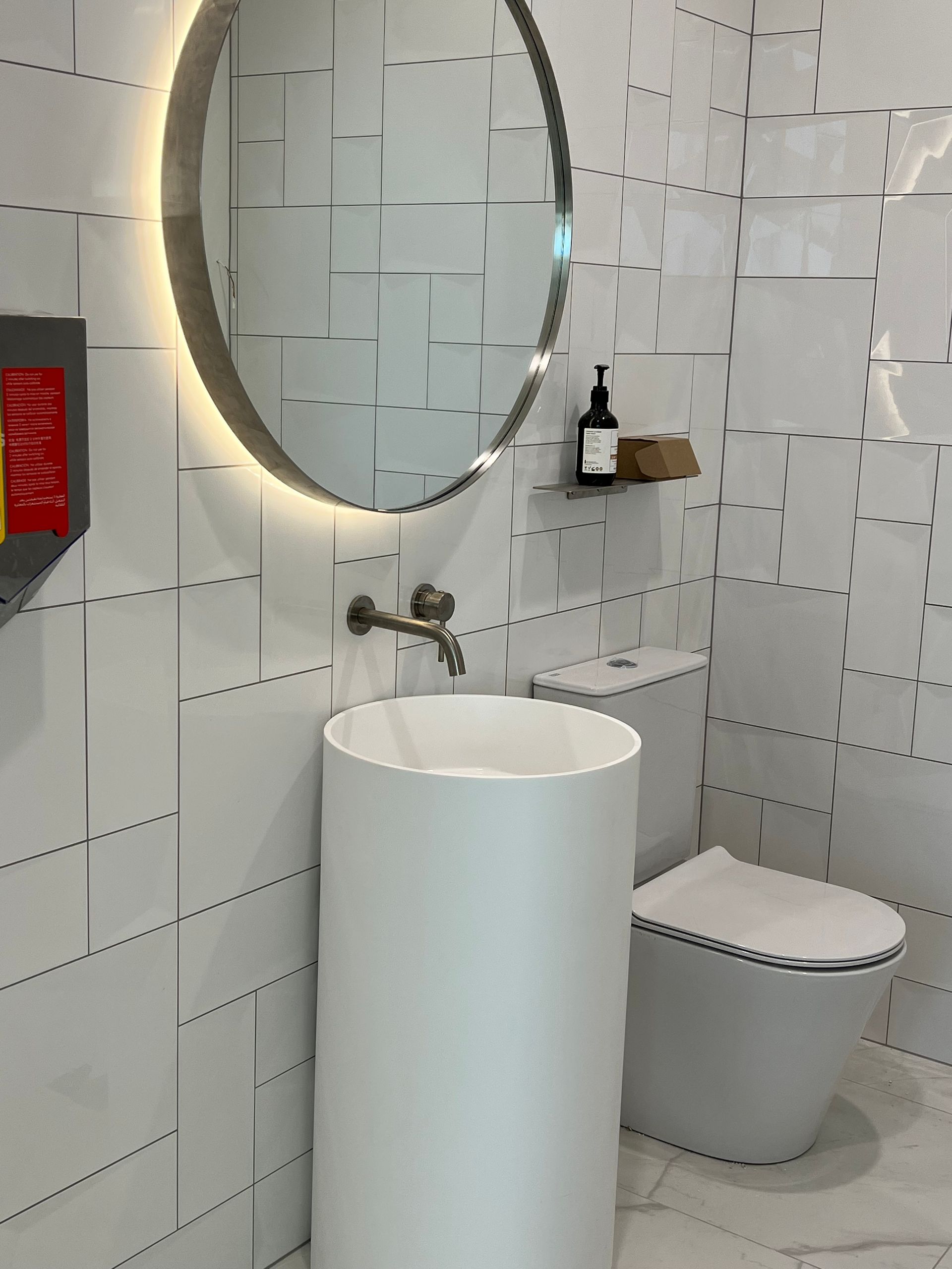 A bathroom with a toilet , sink and mirror