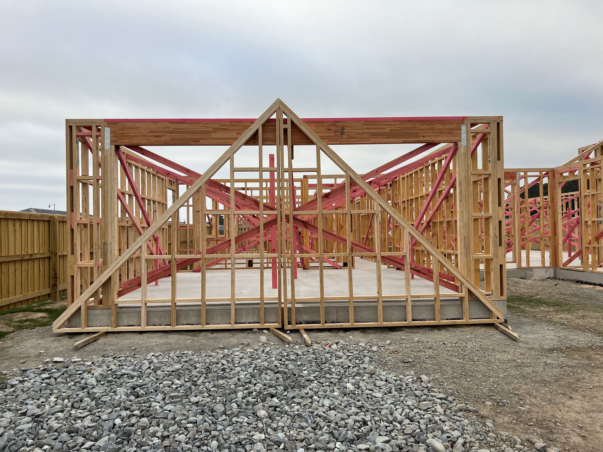 A large wooden structure is sitting on top of a pile of gravel.