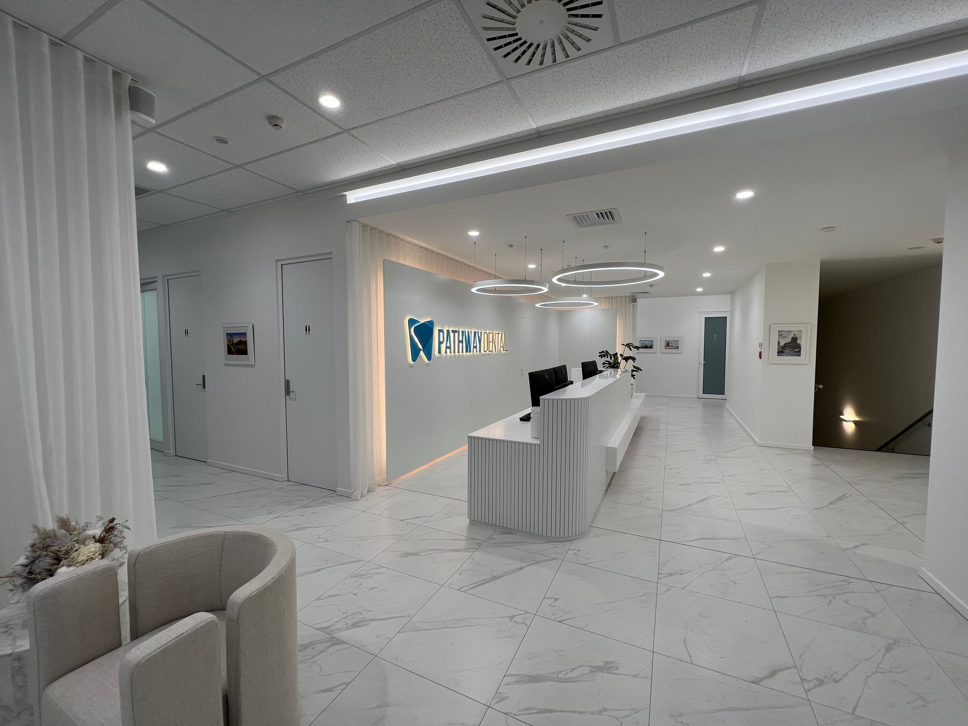 A large room with a reception desk and chairs in it.