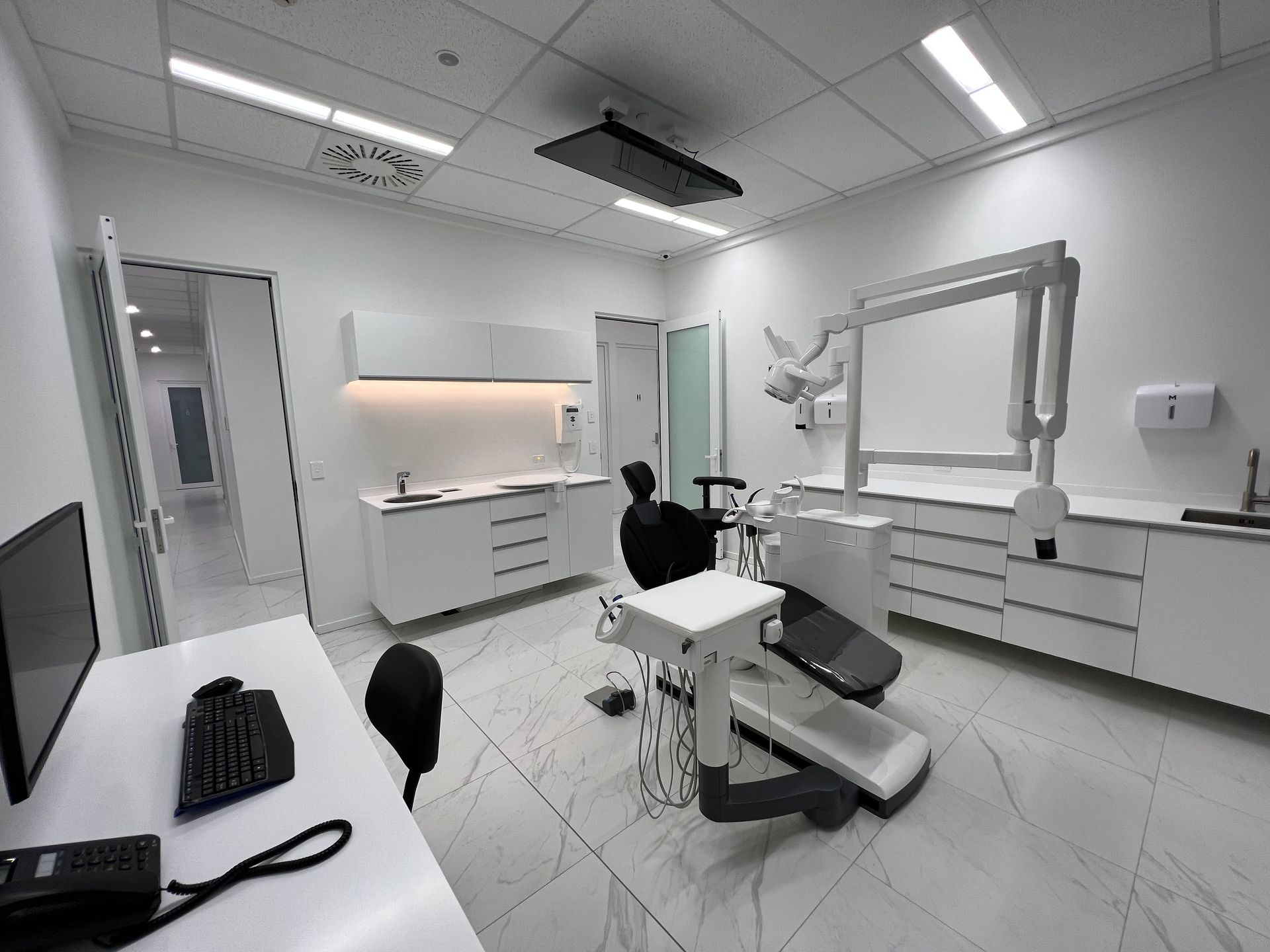 A dental office with a dental chair and a desk.