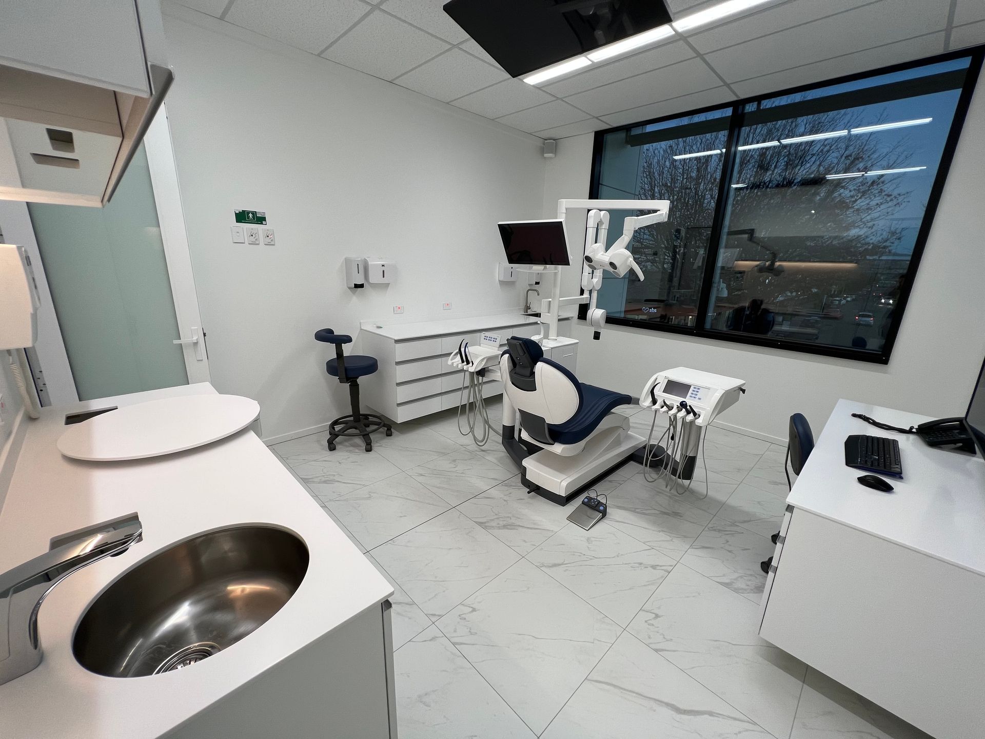 A dental office with a sink and a dental chair.