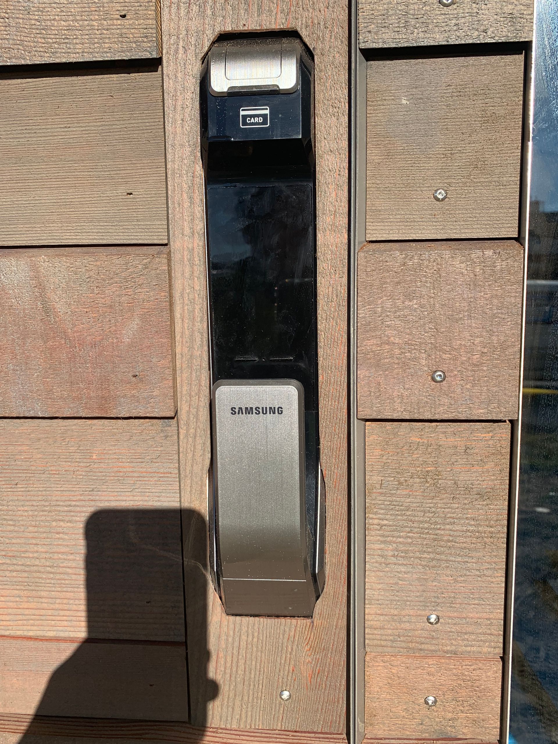 A close up of a door lock on a wooden door.
