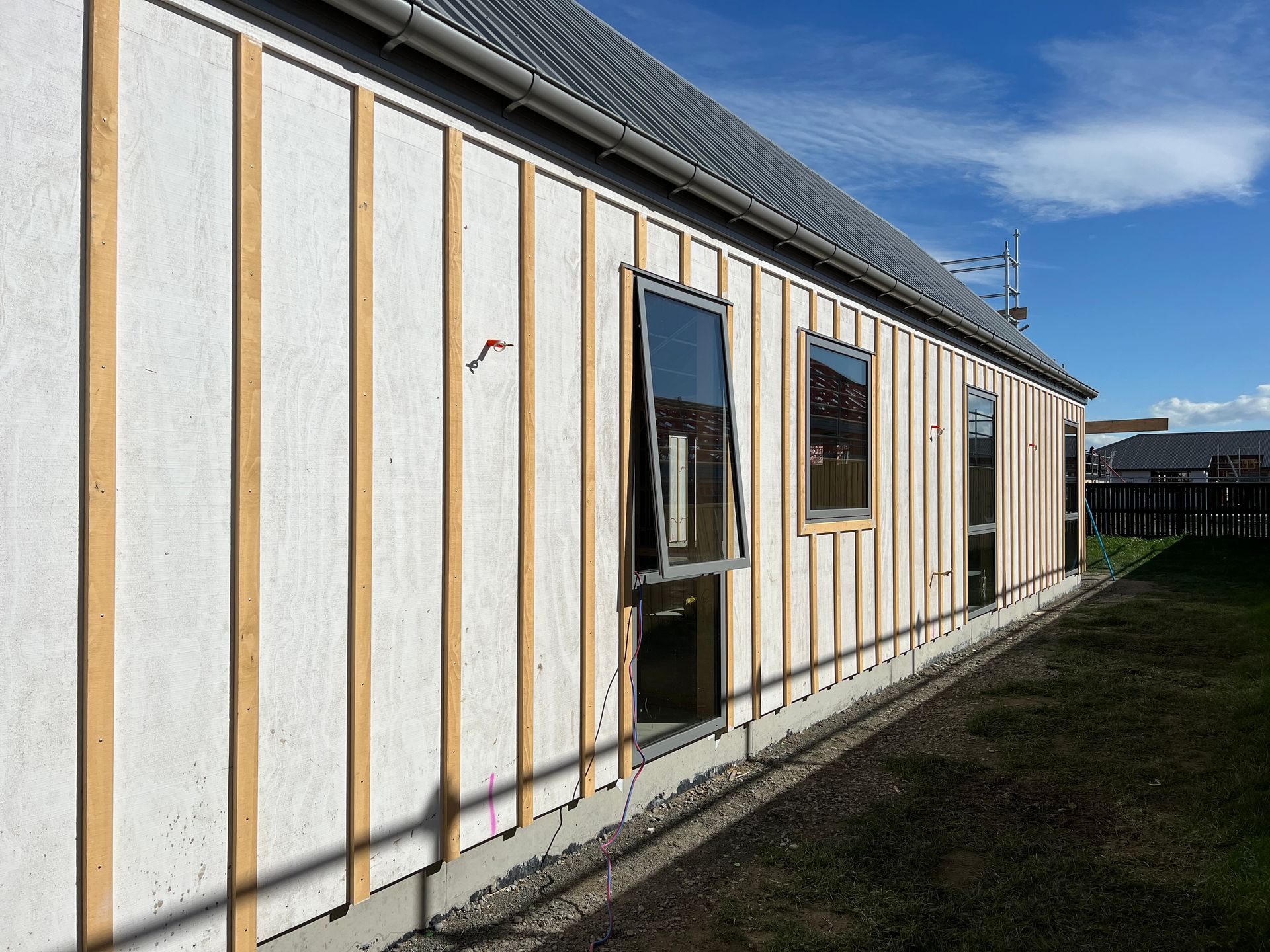 A house with a lot of windows is being built.