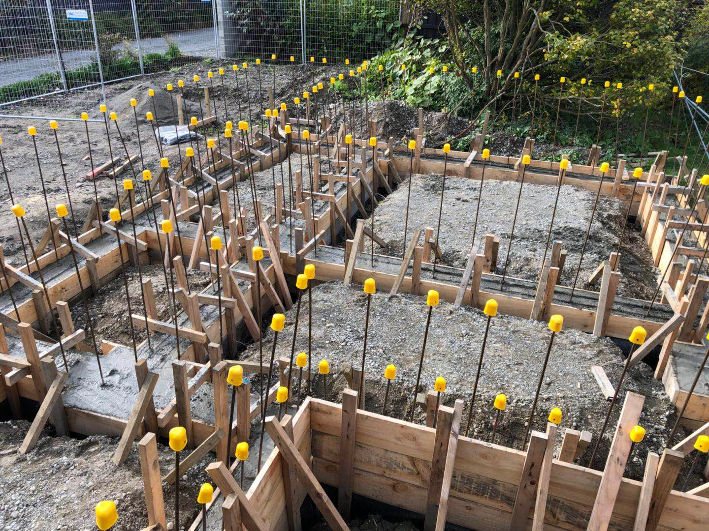 A construction site with a lot of wooden fences and yellow caps.