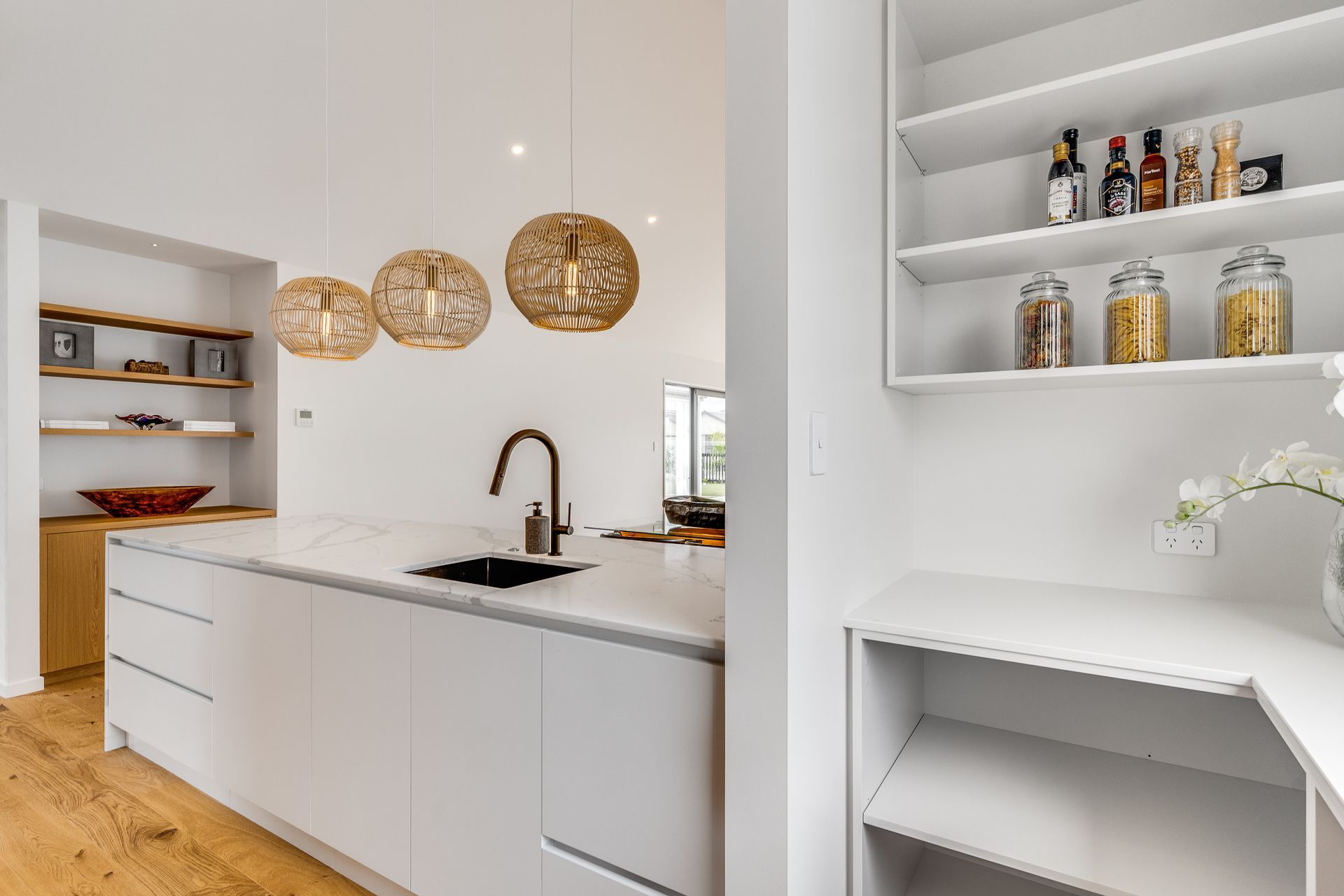 A kitchen with white cabinets , a sink , and a pantry.