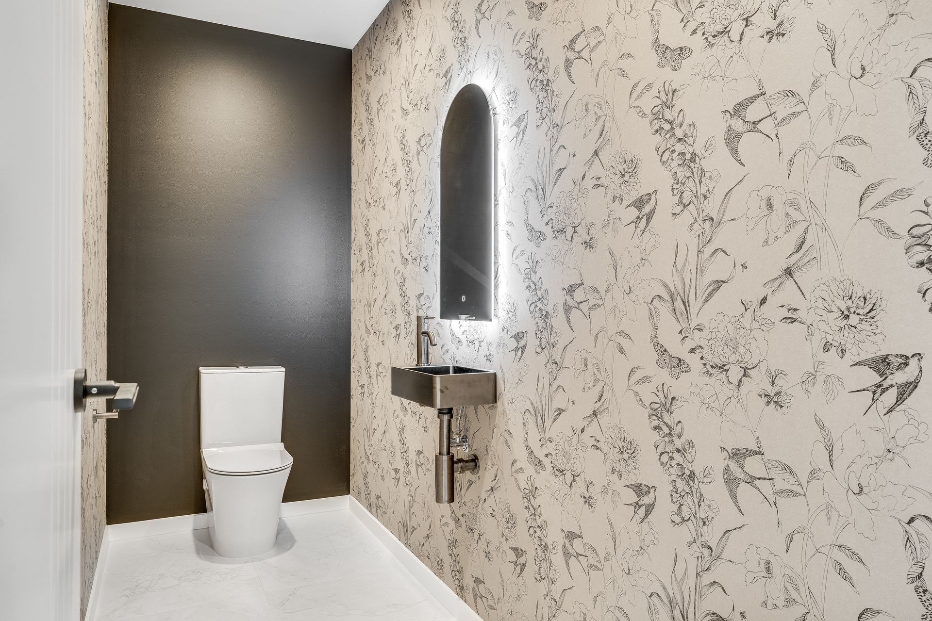 A bathroom with a toilet , sink and mirror.