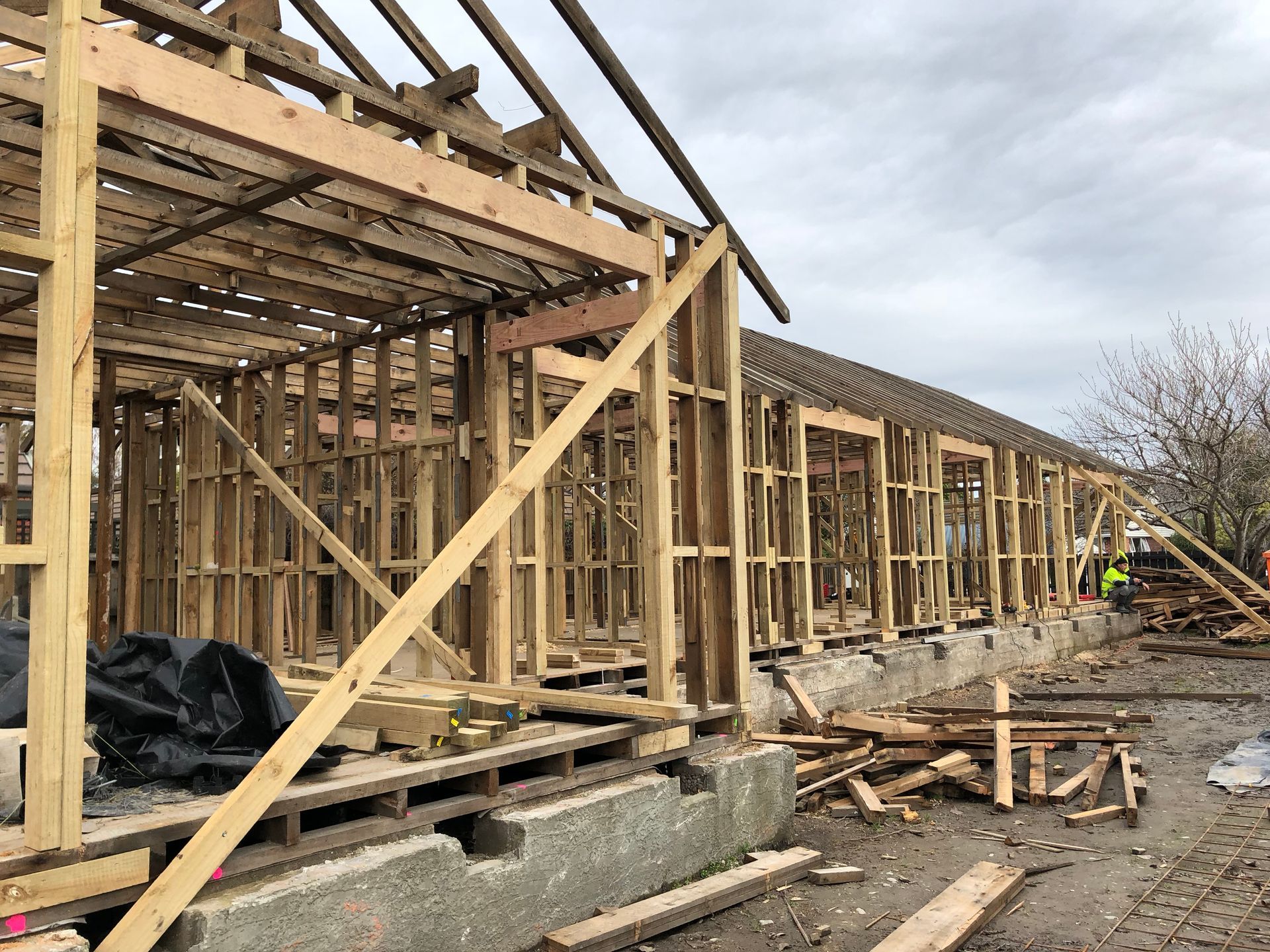 A large wooden structure is being built on a dirt field.