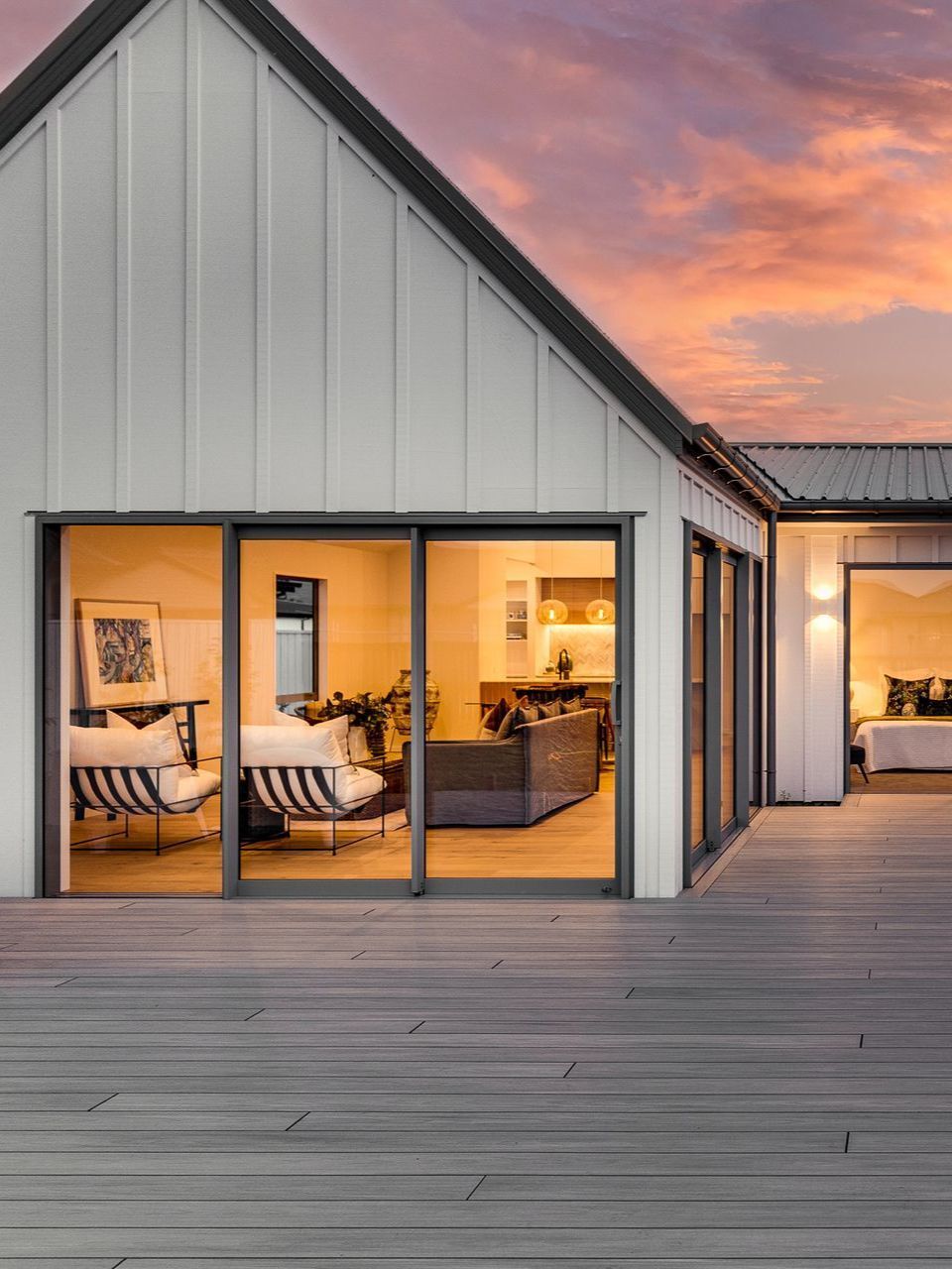 A house with a lot of windows and a wooden deck