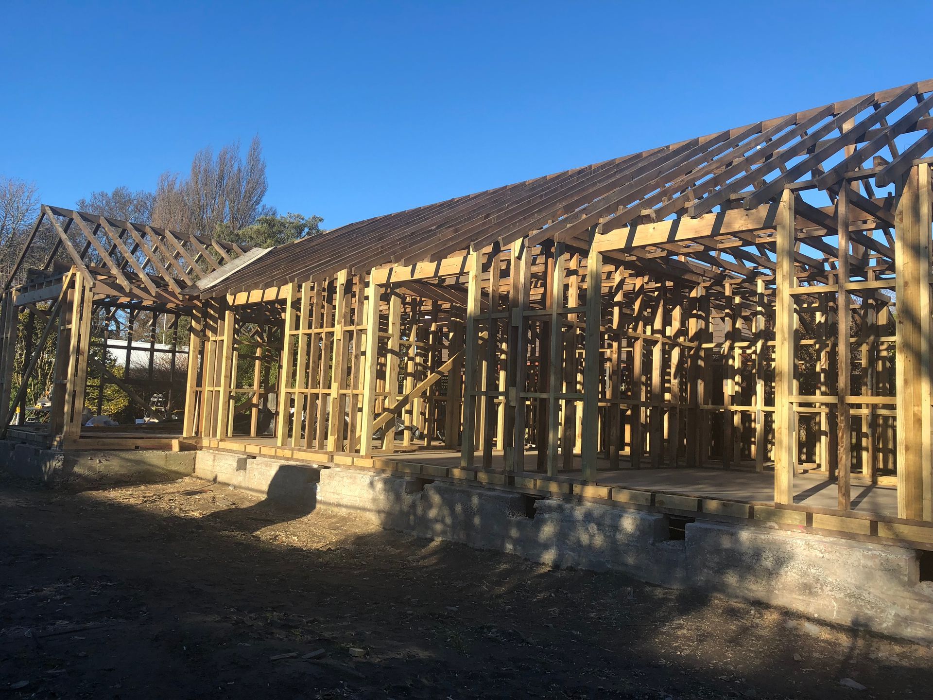 A large wooden structure is being built with a blue sky in the background.