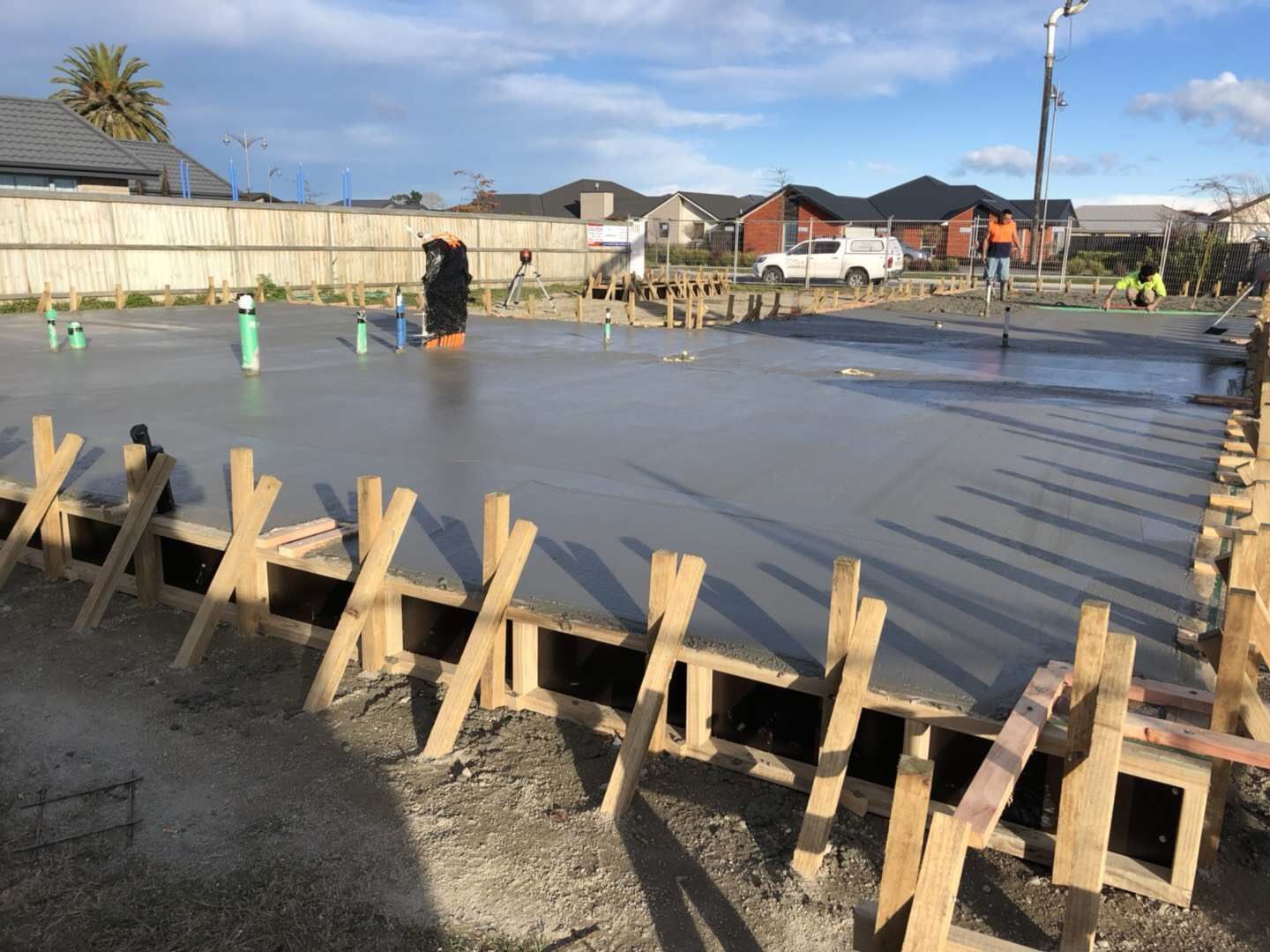 A concrete floor is being poured on a construction site.