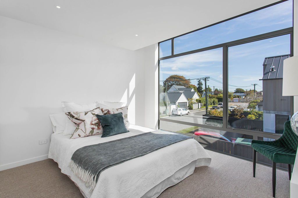A bedroom with a large bed and a large window.