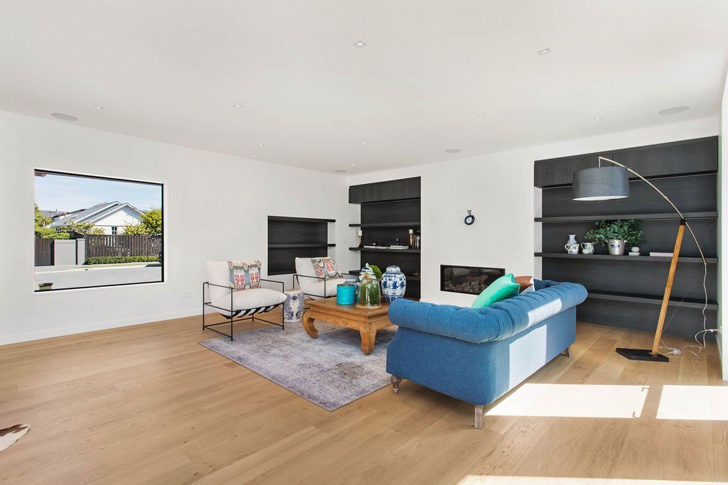 A living room with a blue couch and a wooden floor