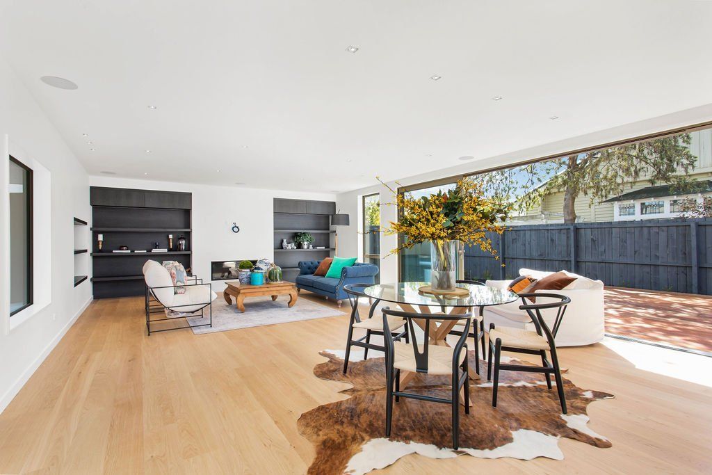 A living room and dining room in a house with a cowhide rug on the floor.