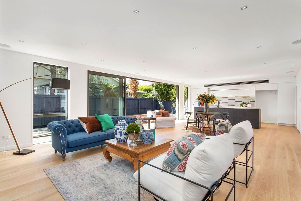 A living room with a blue couch and a white chair.