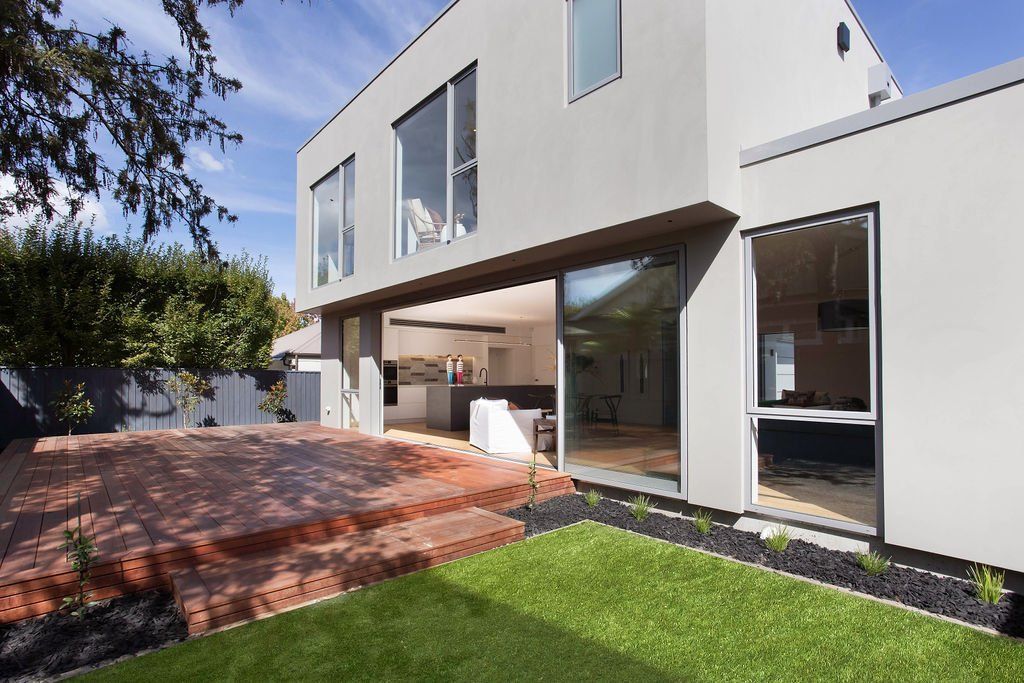 A large house with a lot of windows and sliding glass doors