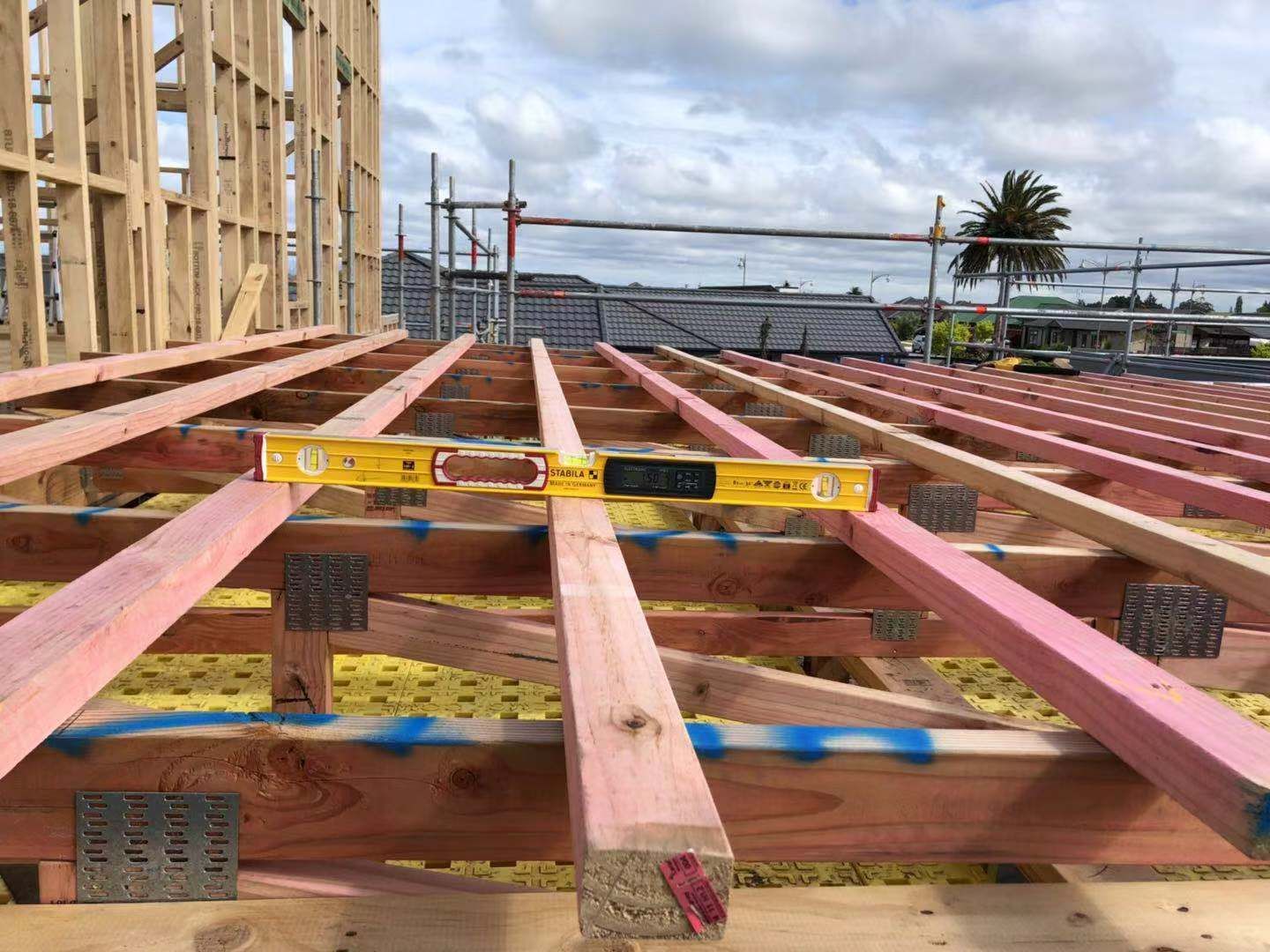A yellow level is sitting on top of a wooden structure.