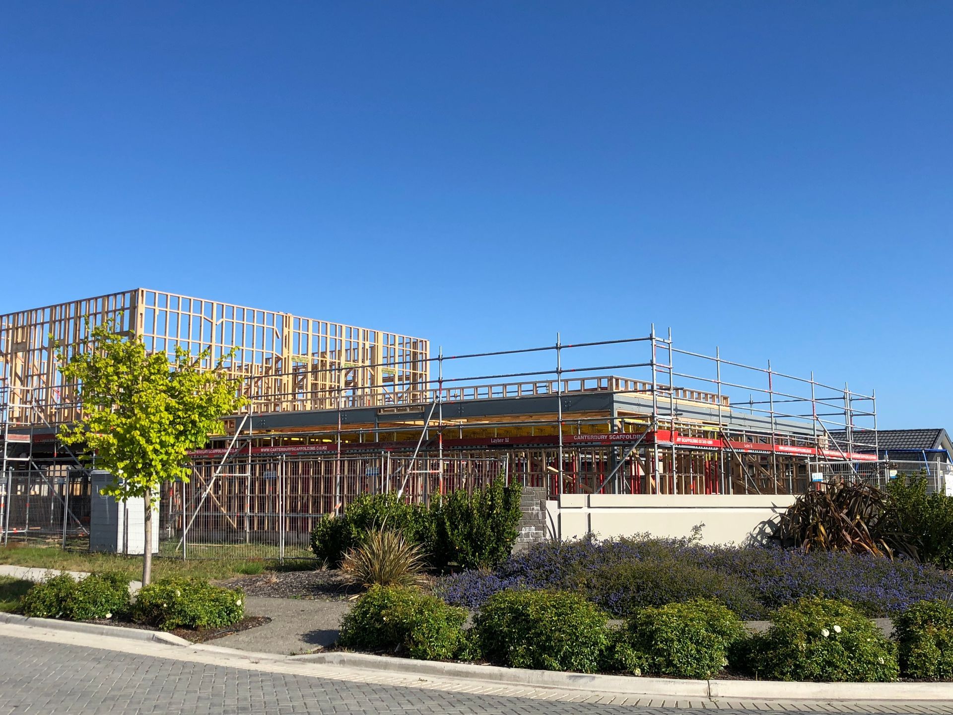 A house is being built with scaffolding and a blue sky in the background.