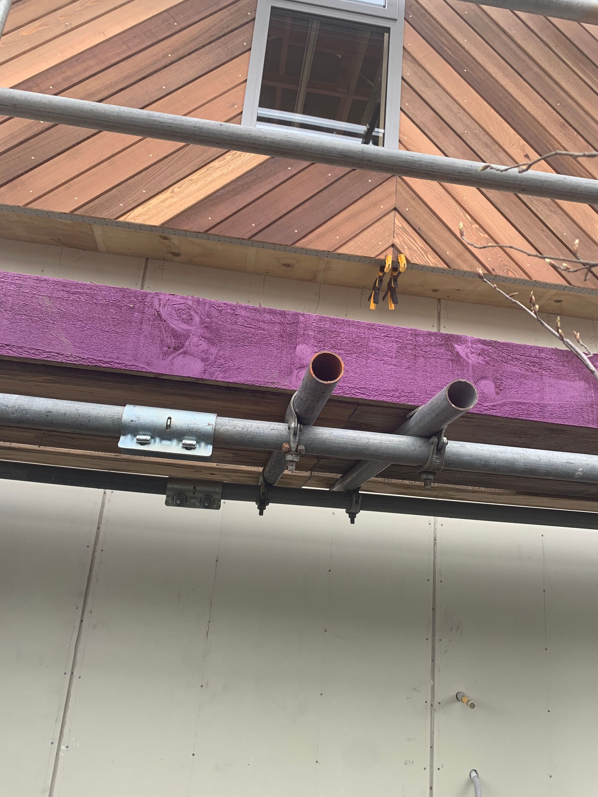 A pipe is hanging from the side of a building.