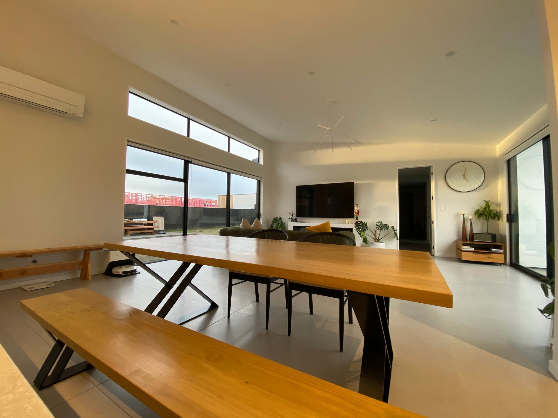 A living room with a large wooden table and benches