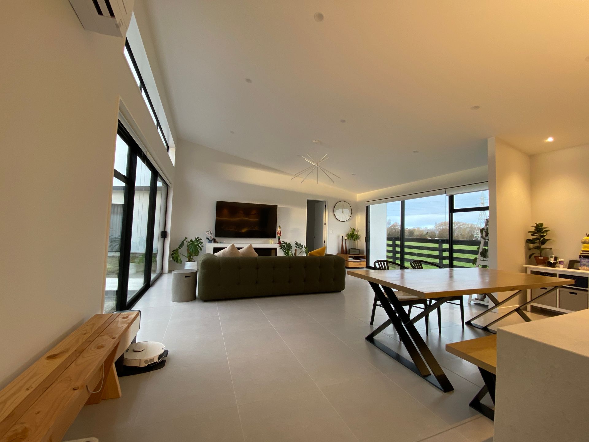 A living room with a couch , table , chairs and a television.
