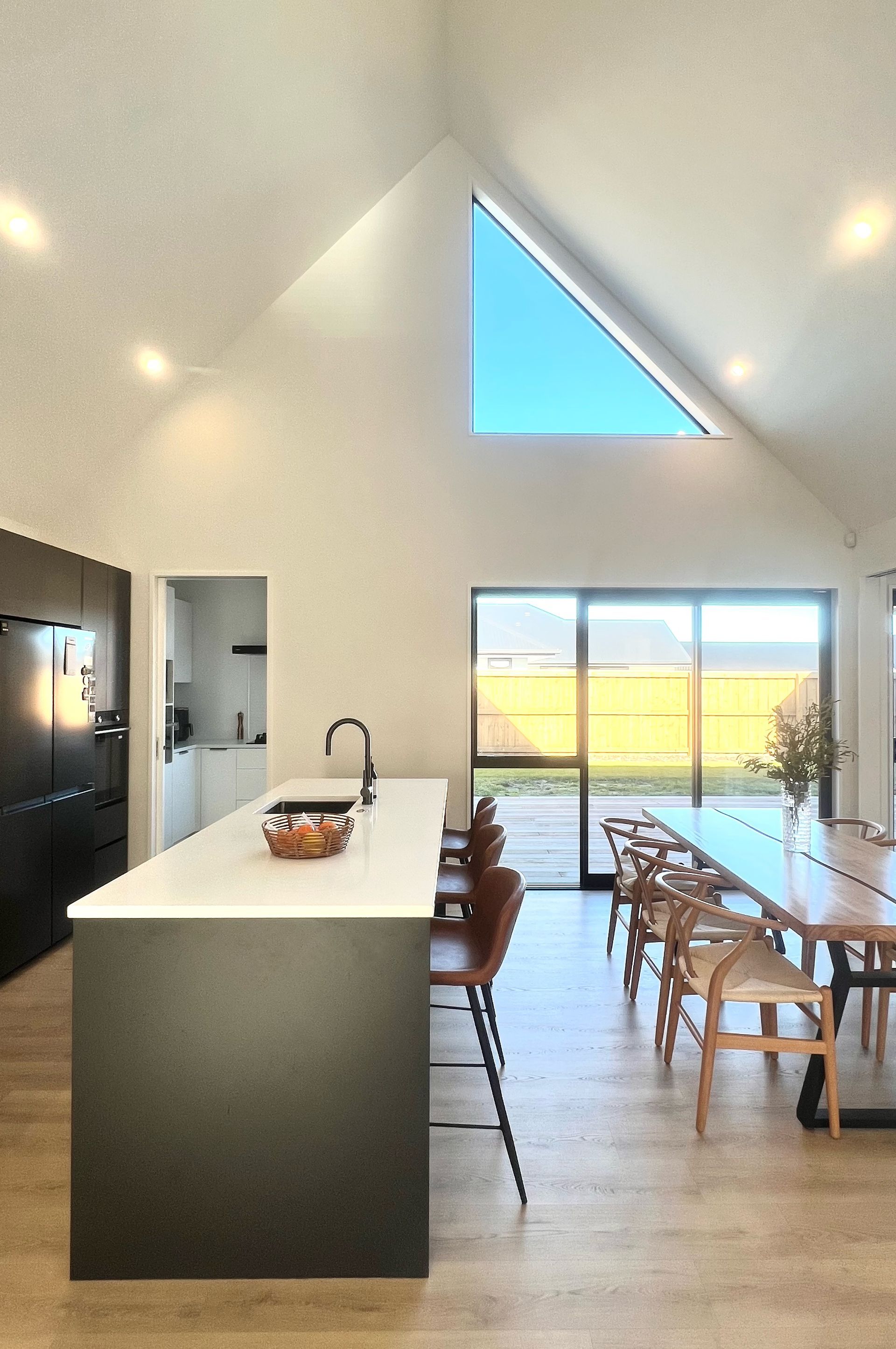 A kitchen and dining room in a house with a large window.