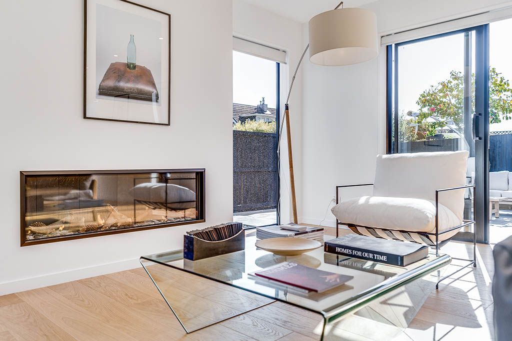 A living room with a fireplace and a glass coffee table