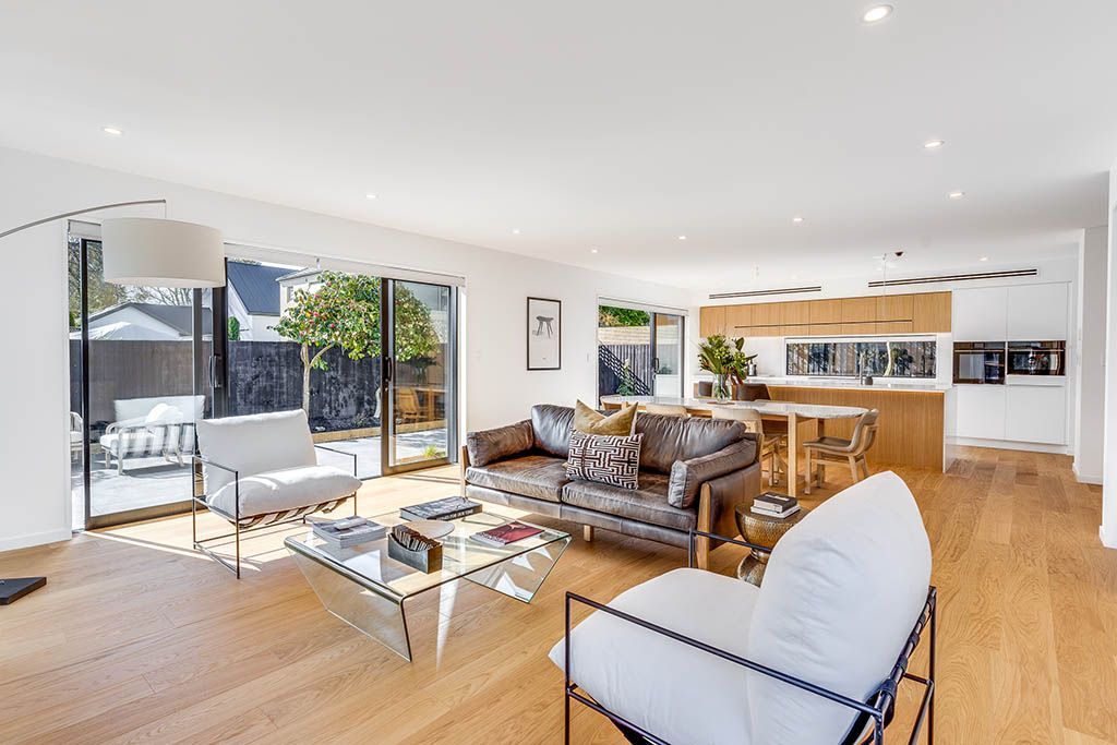 A living room with a couch , chair , coffee table and sliding glass doors.