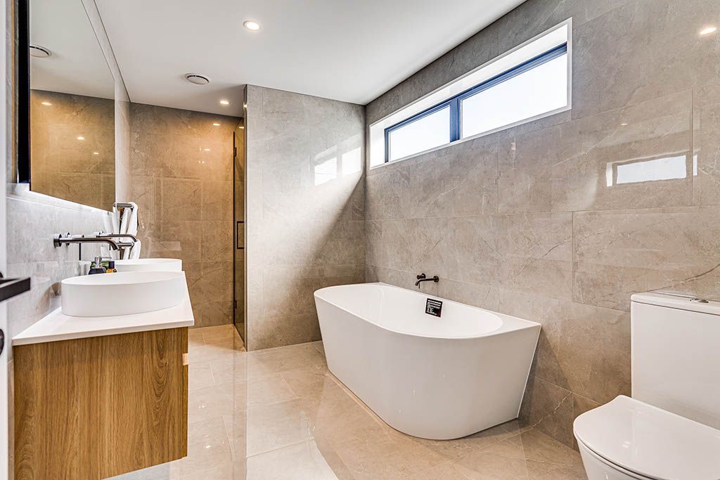 A bathroom with a bathtub , toilet , sink and mirror.