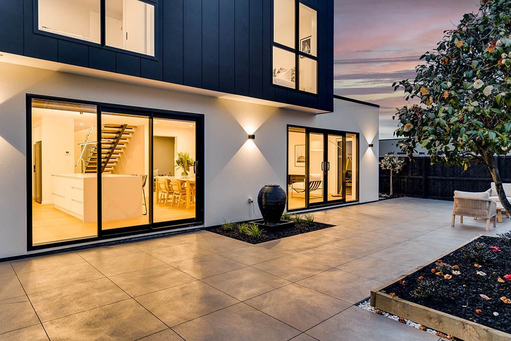 A large house with a lot of windows and a patio in front of it.