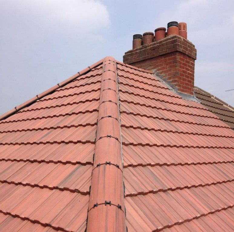 Picture of a new hipped roof by Roofers Nottingham in dark English Red conrete tile