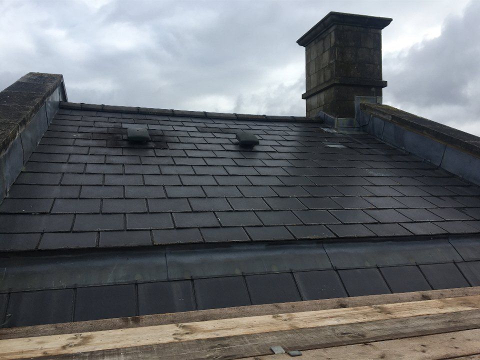 Picture of a new cottage roof replaced in black synthetic slate