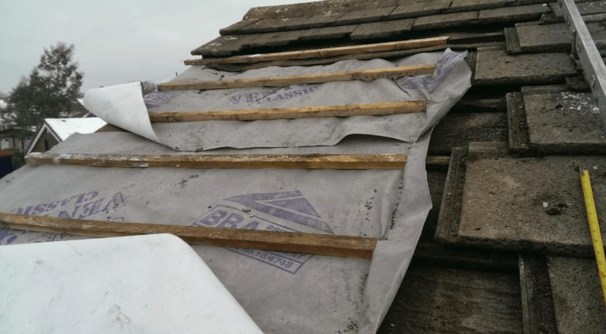Picture of a roof repair taking place on a stone tile roof by Roofers Nottingham