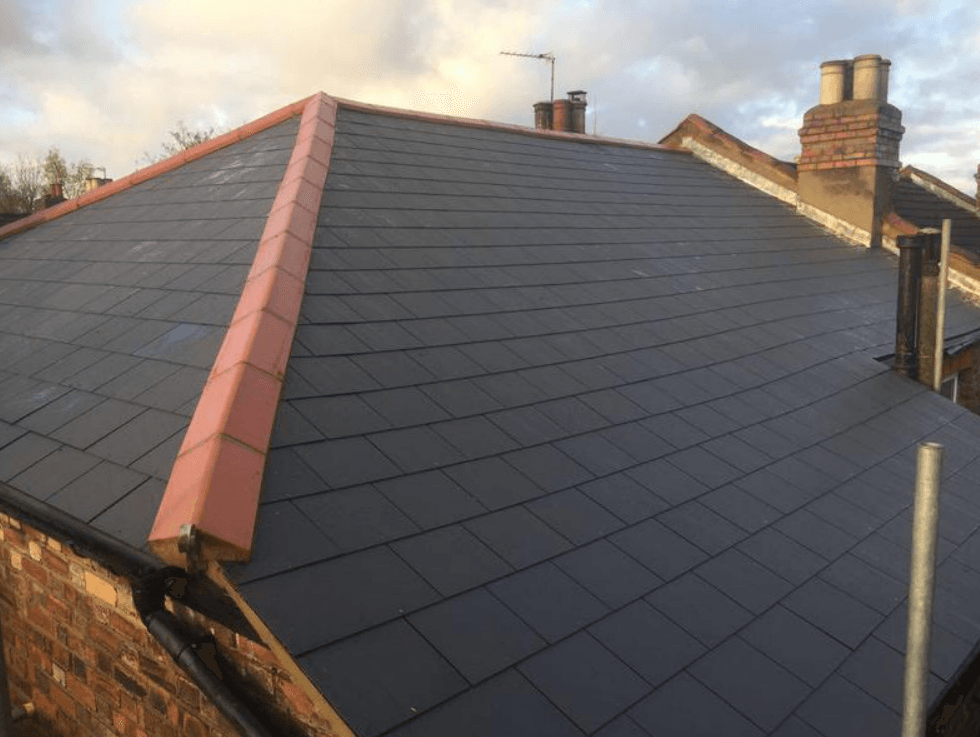 Picture of a new hipped roof replaced with grey synthetic slate tiles and red clay ridge tiles by Roofers Nottingham