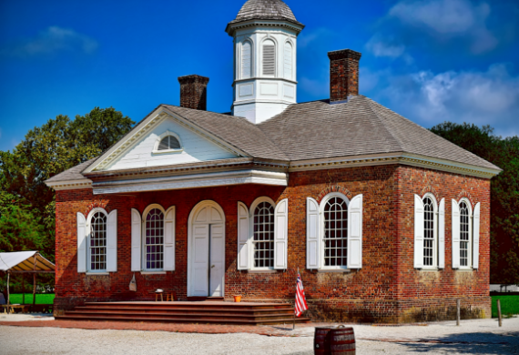 A large red brick building with white shutters and a clock tower.