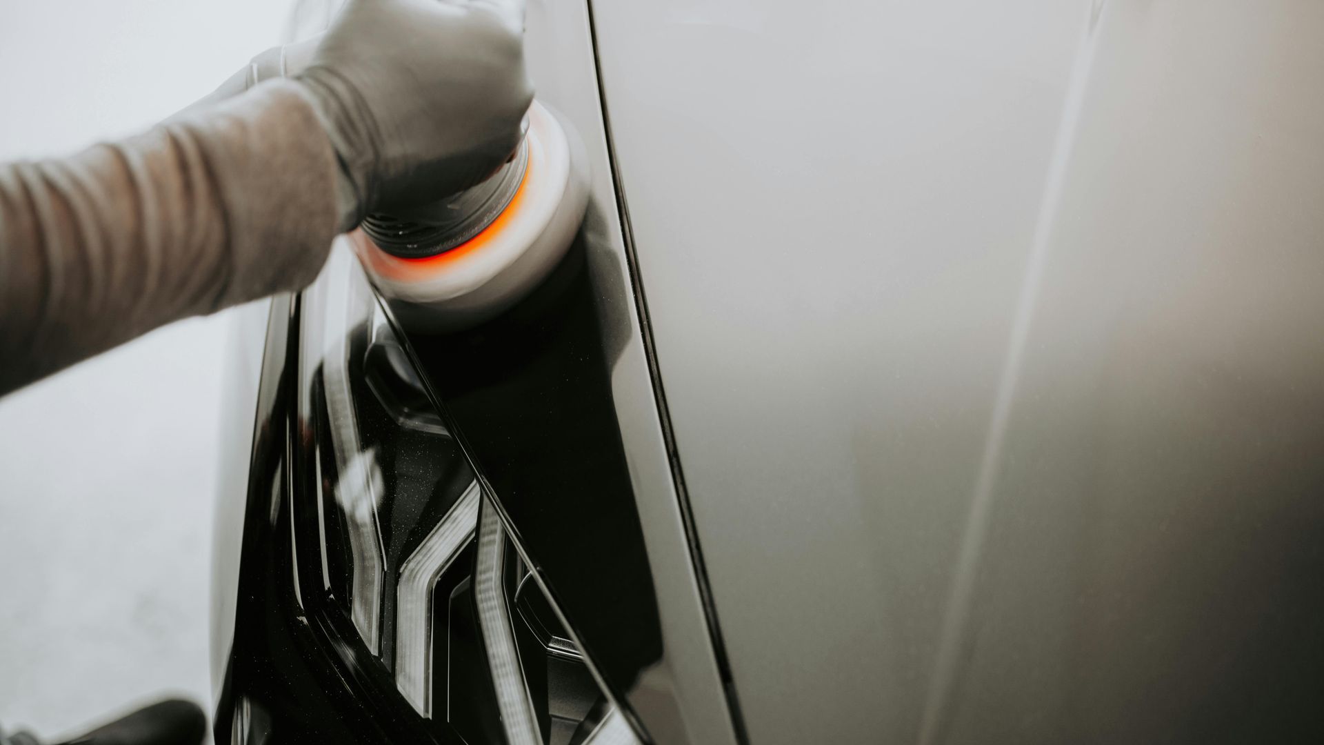 A person is polishing a car with a machine.