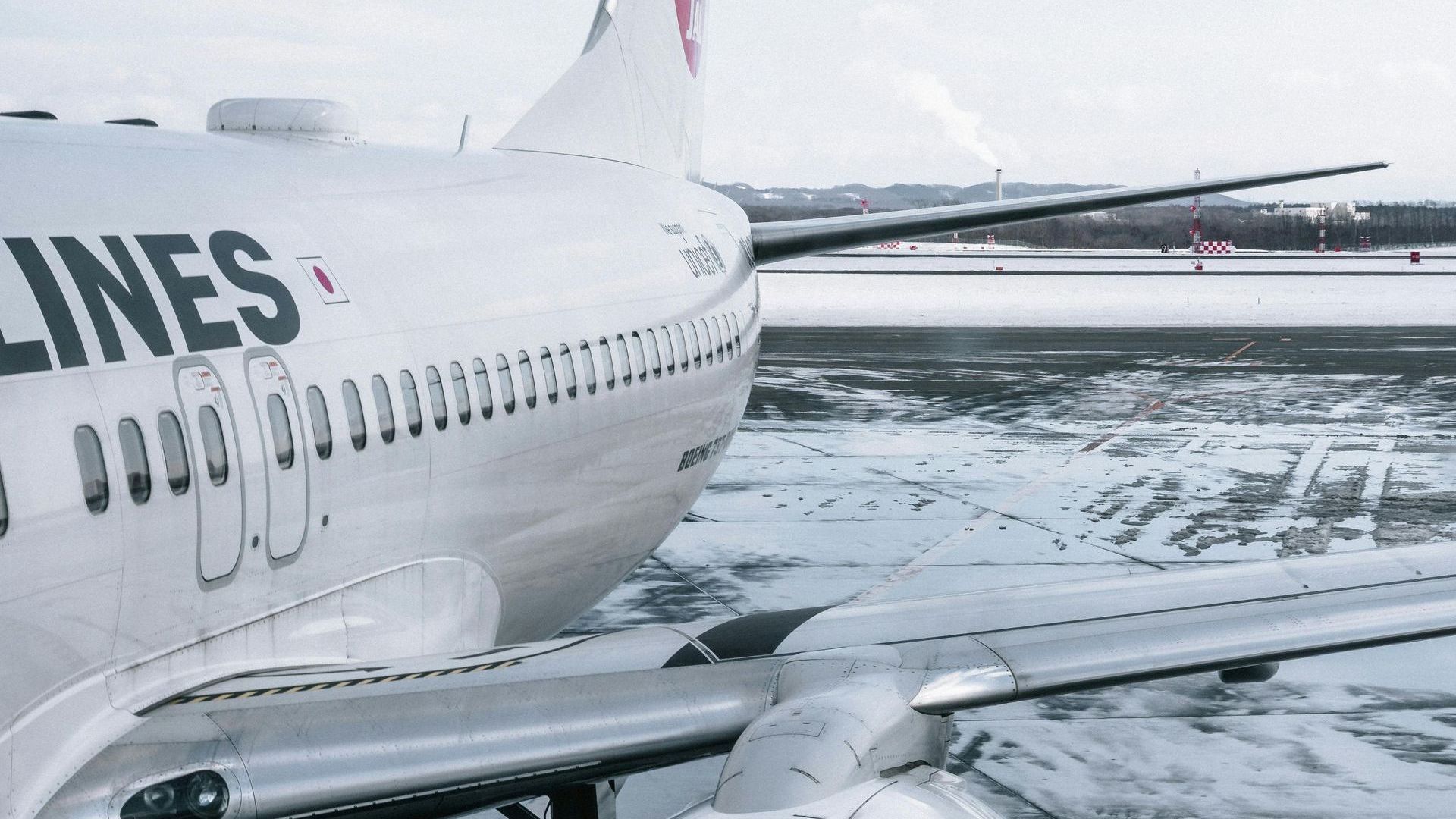 A white airplane is parked on a snowy runway.