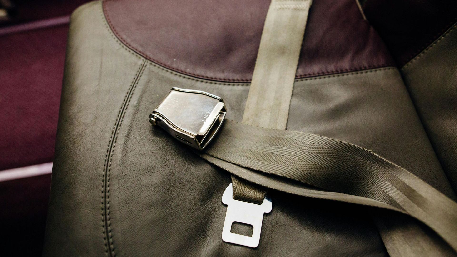 A close up of a seat belt on an airplane seat