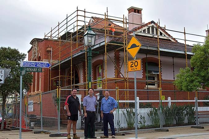Three Men Standing in Front of a Building With a Sign — Roofpoint In Kawungan, QLD
