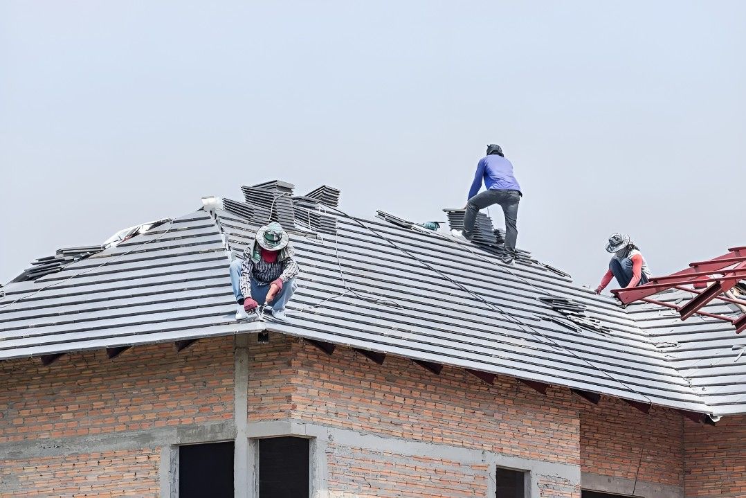A Group of Construction Workers Are Working on the Roof of a Building— Roofpoint In Kawungan, QLD