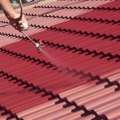 A Person is Spraying Paint on a Red Roof — Roofpoint In Kawungan, QLD