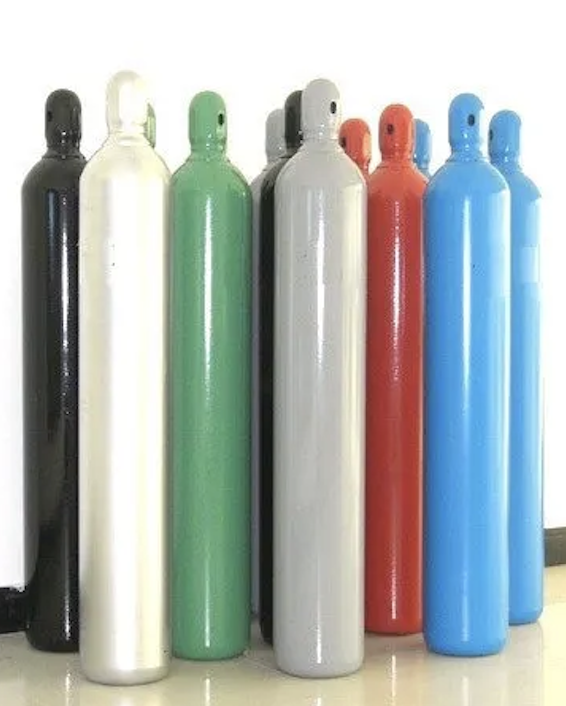 Collection of colorful compressed gas cylinders. Cylinders are black, white, green, grey, red, and blue.