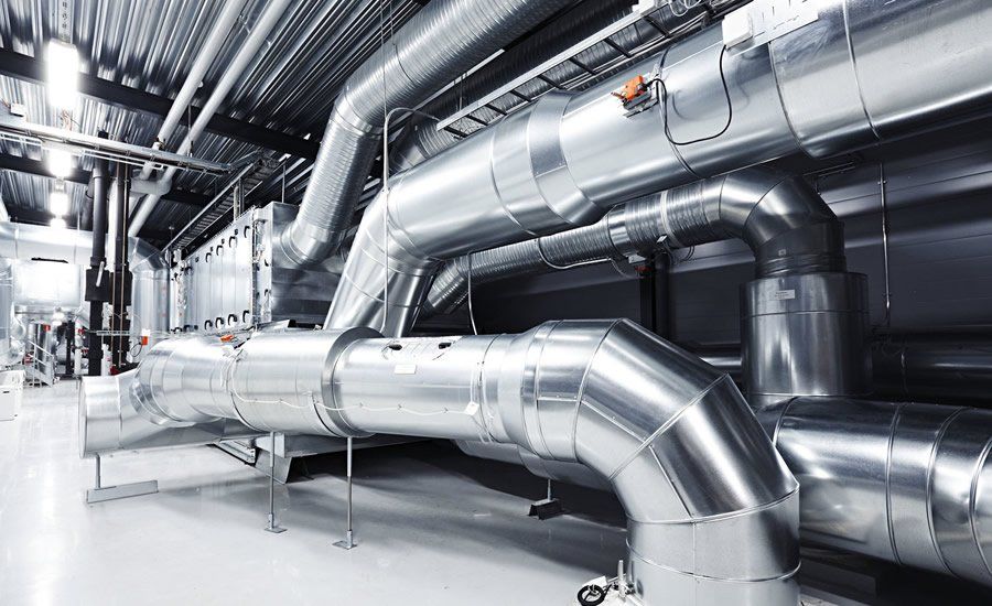Metallic industrial pipes in a bright, modern mechanical room.