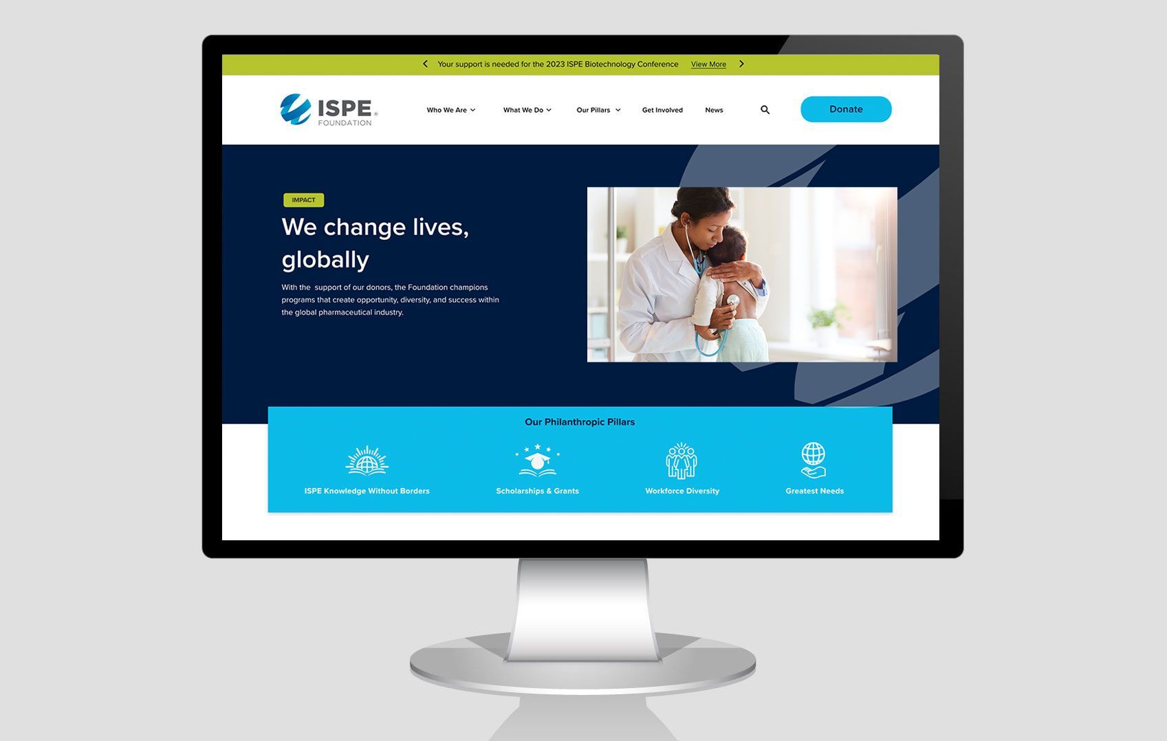 A computer monitor is displaying a website with a picture of a woman holding a baby.