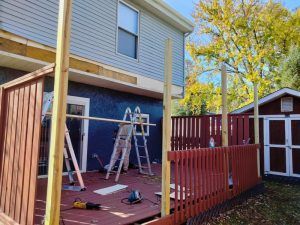 A wooden deck is being built in front of a house.