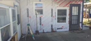 A house is being remodeled with a ladder and a shovel.