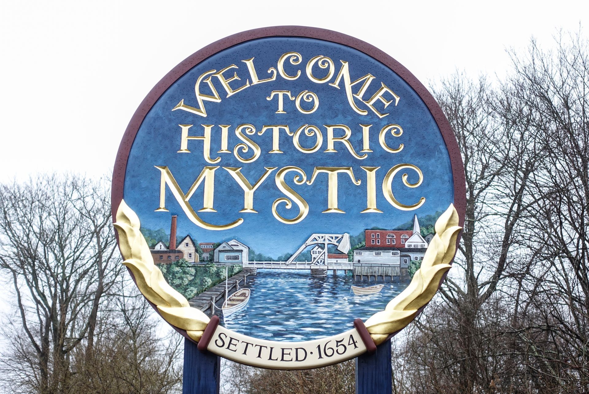 A sign that says welcome to historic mystic on it