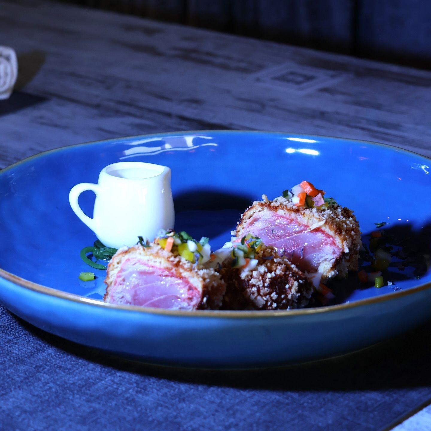 Un piatto blu con carne e verdure sopra