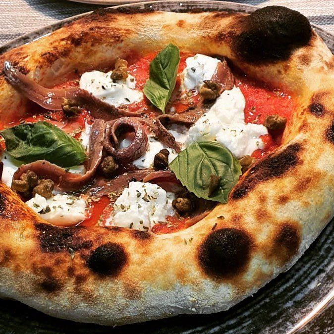pizza con acciughe, basilico e origano