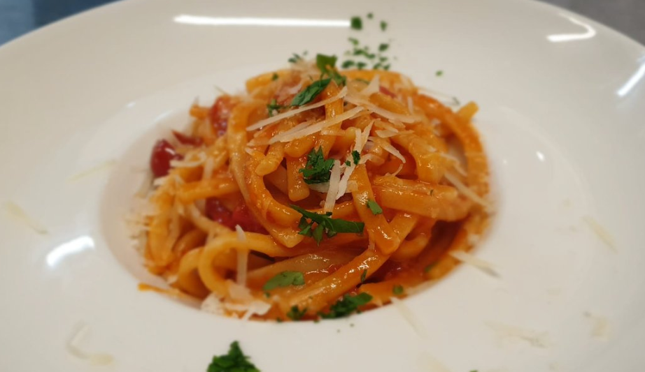 bucatini al sugo con formaggio grattugiato