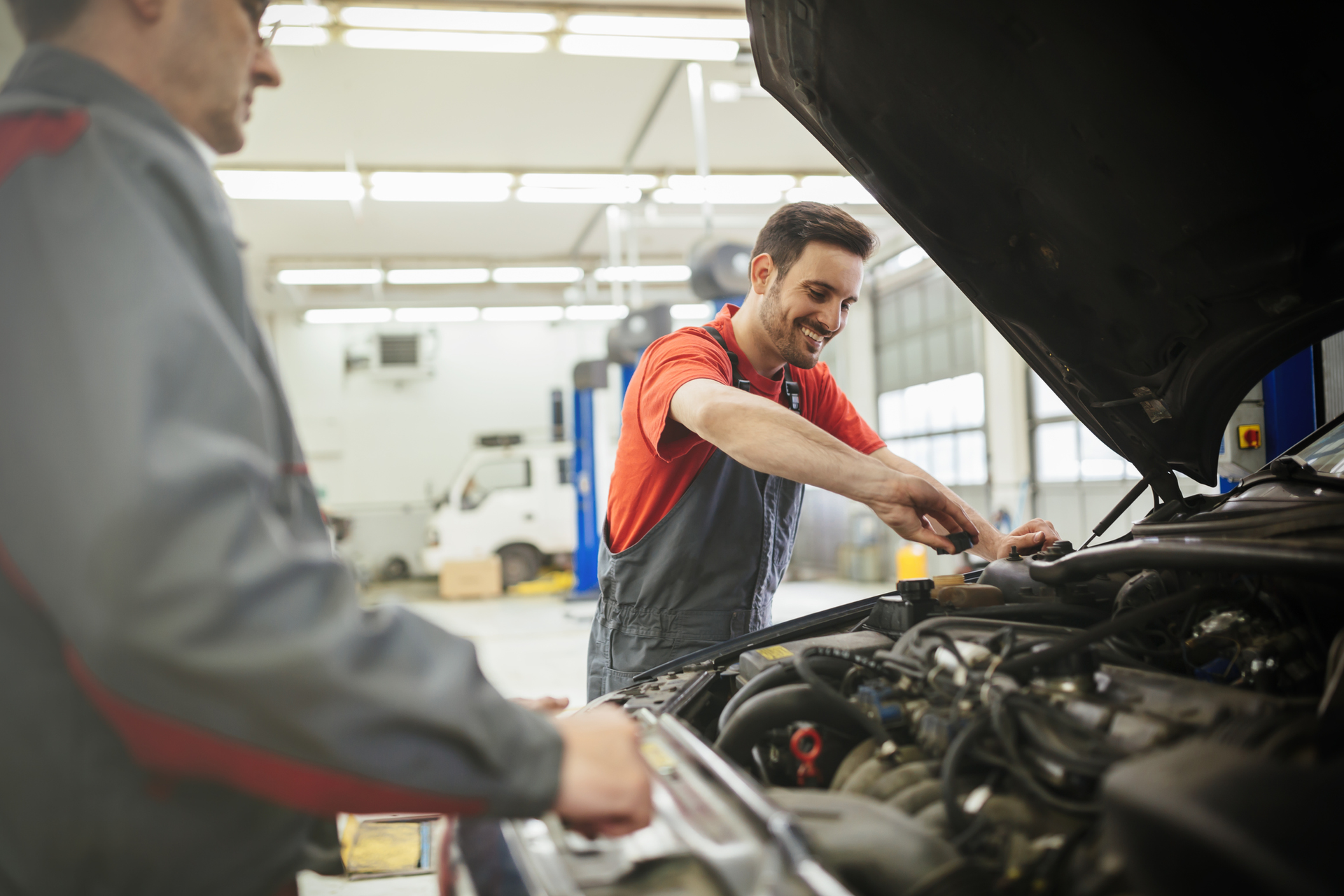 Mechanics performing car maintenance at a professional transmission shop.